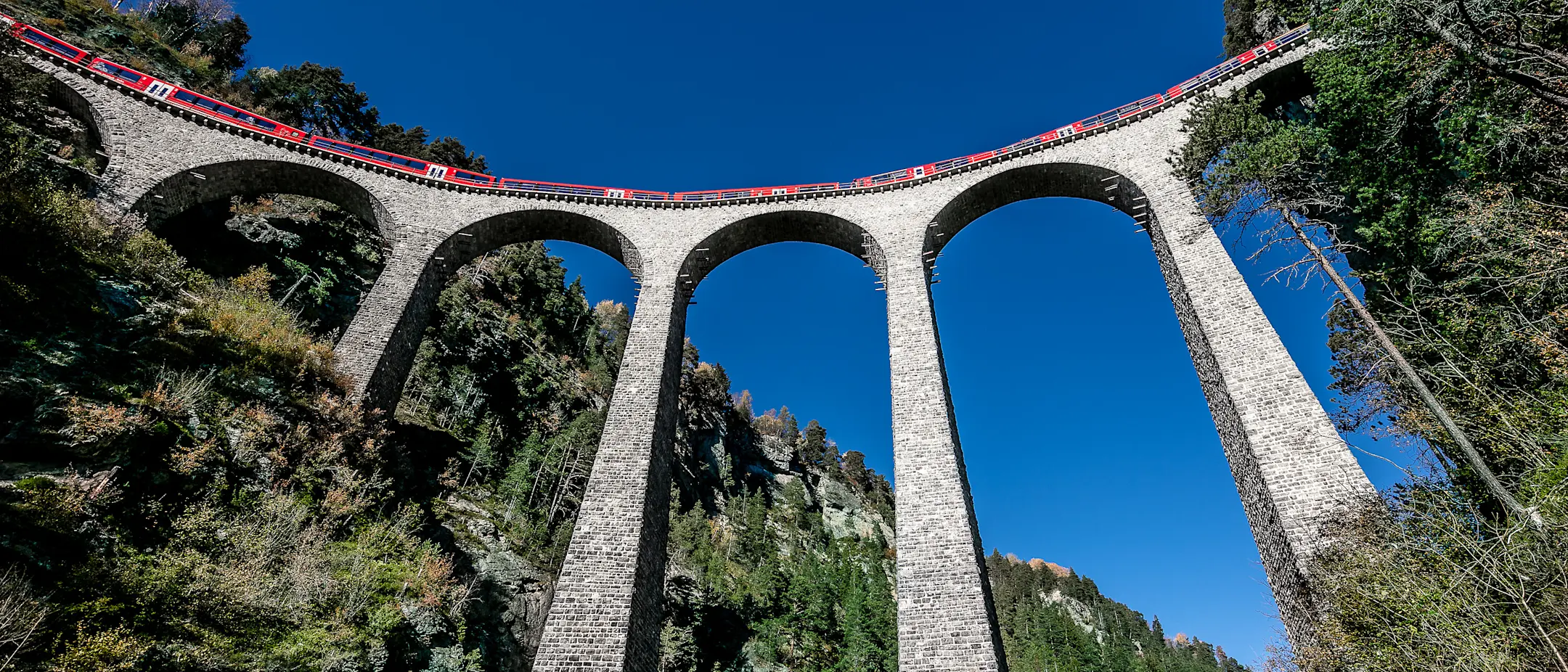 View from below looking up at the Alvra articulated train crossing the Landwasser Viaduct.
