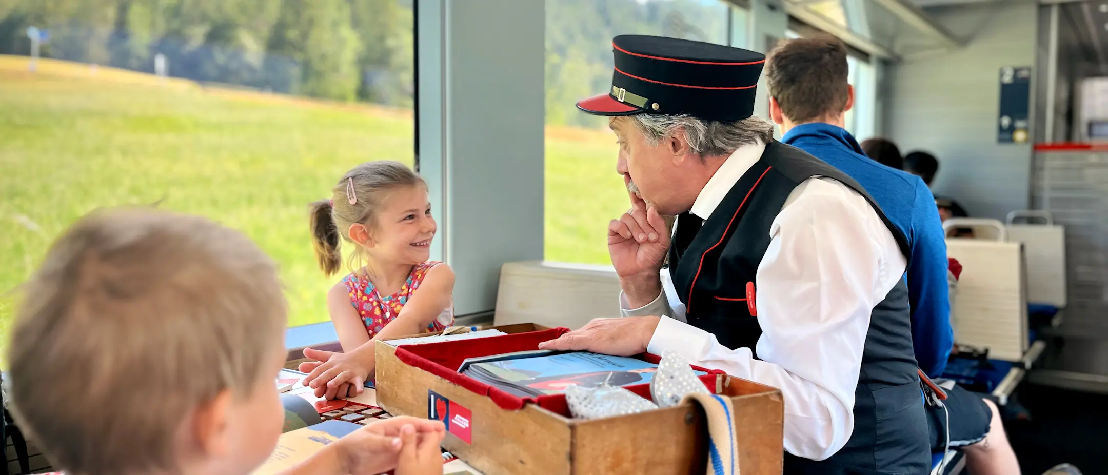 Rhaetian Railway children’s conductor Clà Ferrovia plays with a child in the family compartment