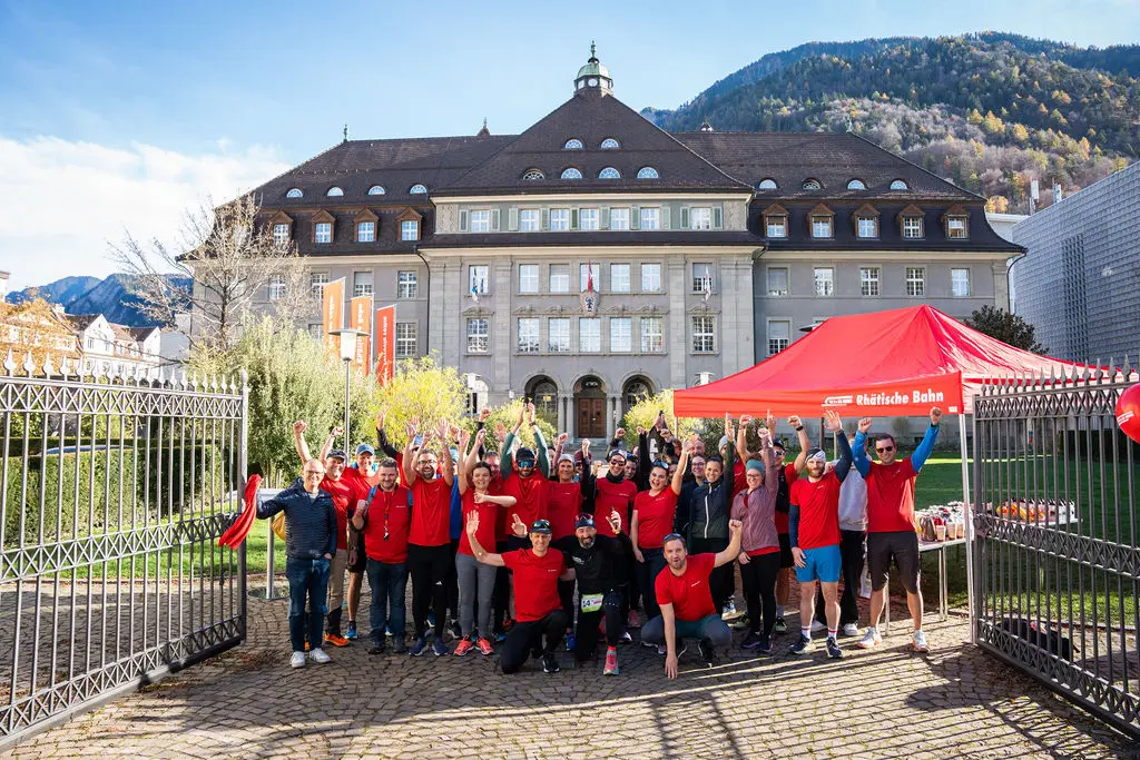 30 Mitarbeitende in Sportkleidung vor dem Verwaltungsgebäude Chur
