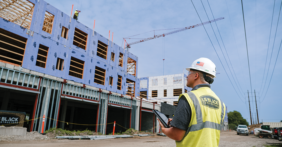 A construction worker uses a tablet on a jobsite