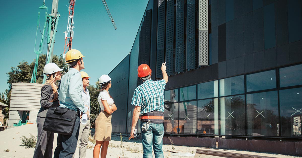 A construction worker shows the project's progress to their clients.