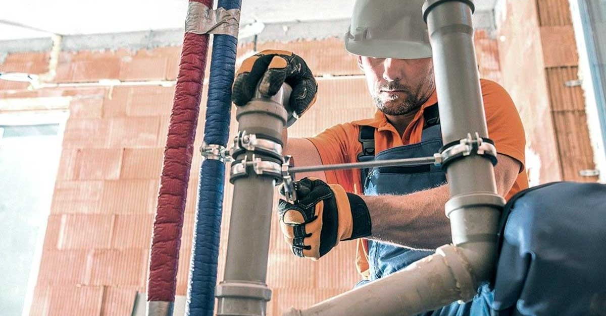 Worker installing MT systems overhead. Jobsite management software like Fieldwire can help mechanical contractors share the latest information and improve quality and productivity.