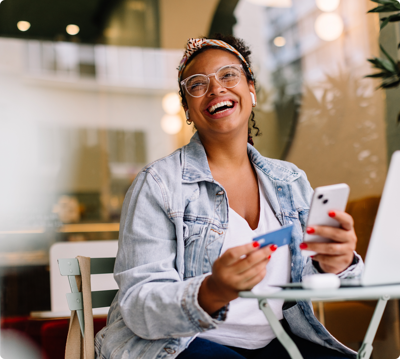 lady in coffee shop with phone and bank card