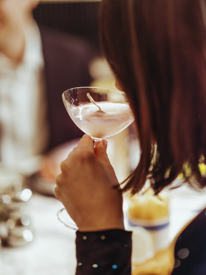 A woman sipping on a martini cocktail