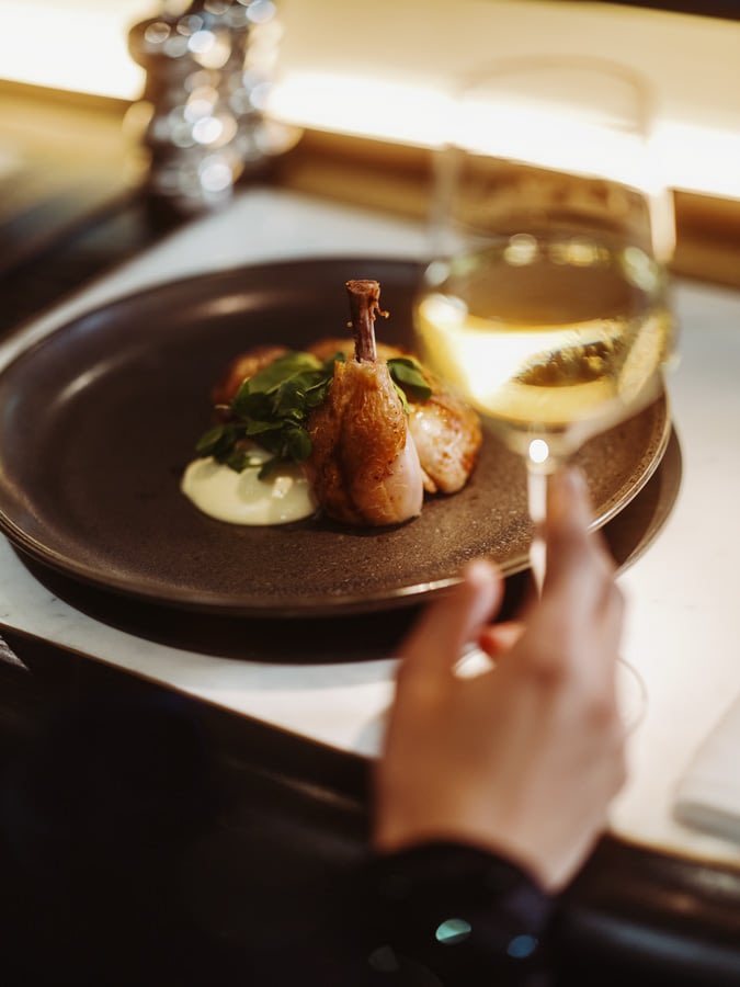 Baby chicken dish with a glass of white wine