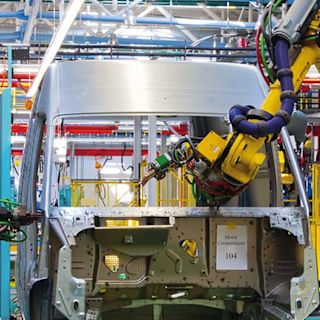 Industrial robot in an automotive production line working on a vehicle body