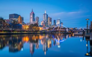 Skyline einer Stadt bei Sonnenuntergang mit Spiegelung der Gebäude im Wasser