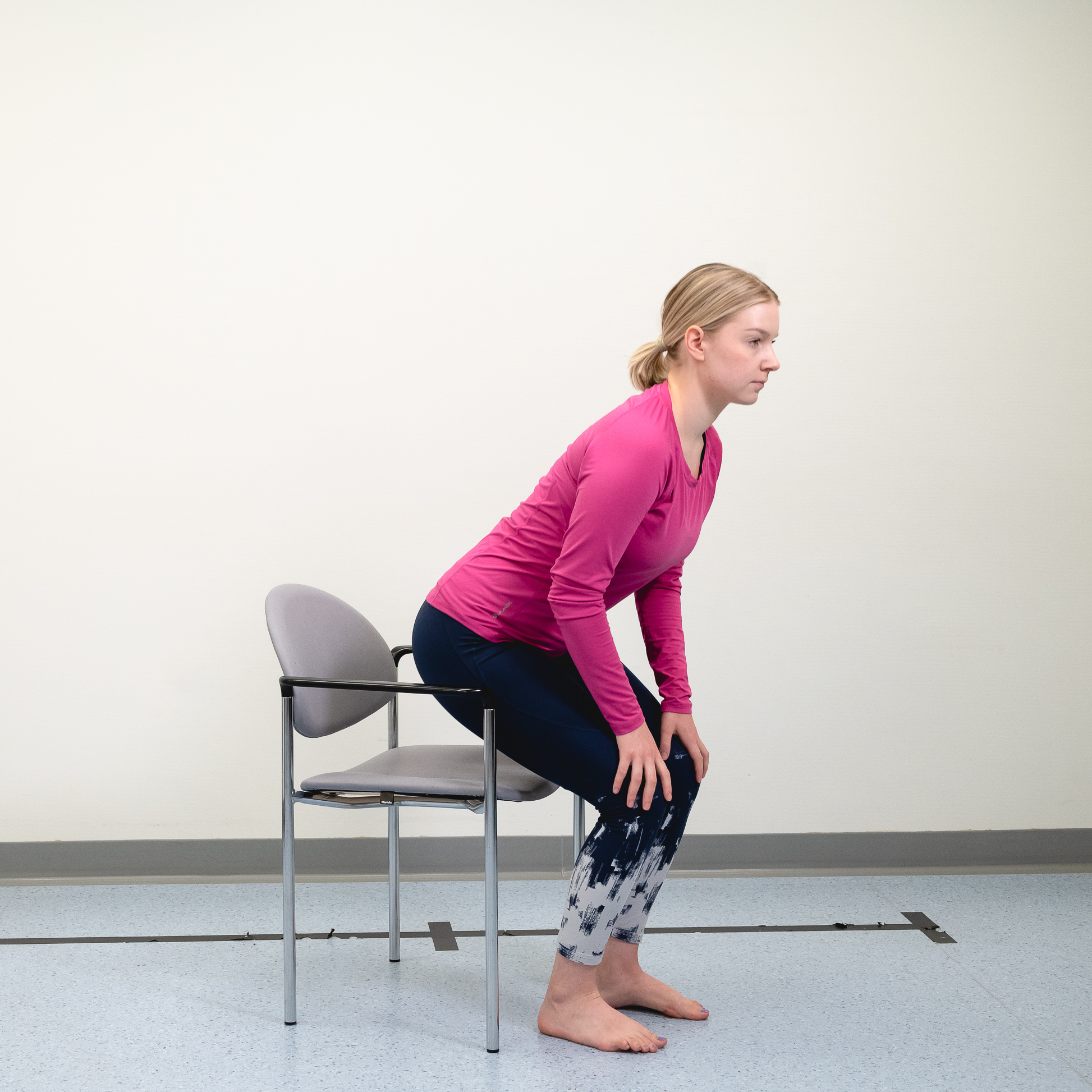 Kvinna reser sig från sittande till stående.