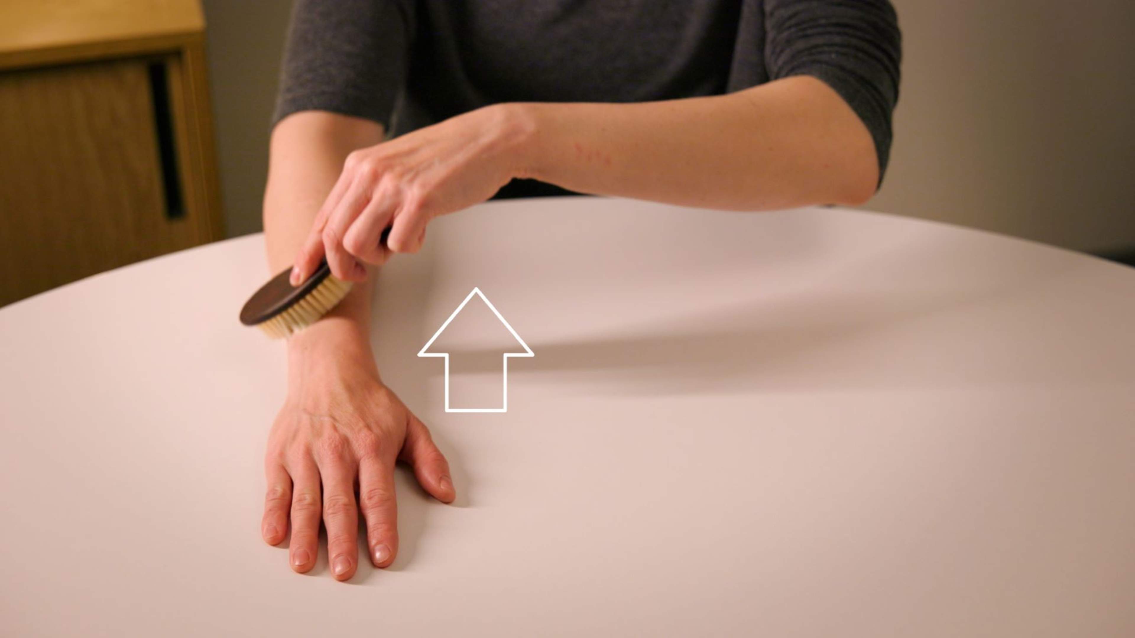 En person borstar sin hand från fingertopparna mot underarmen, med handryggen uppåt.