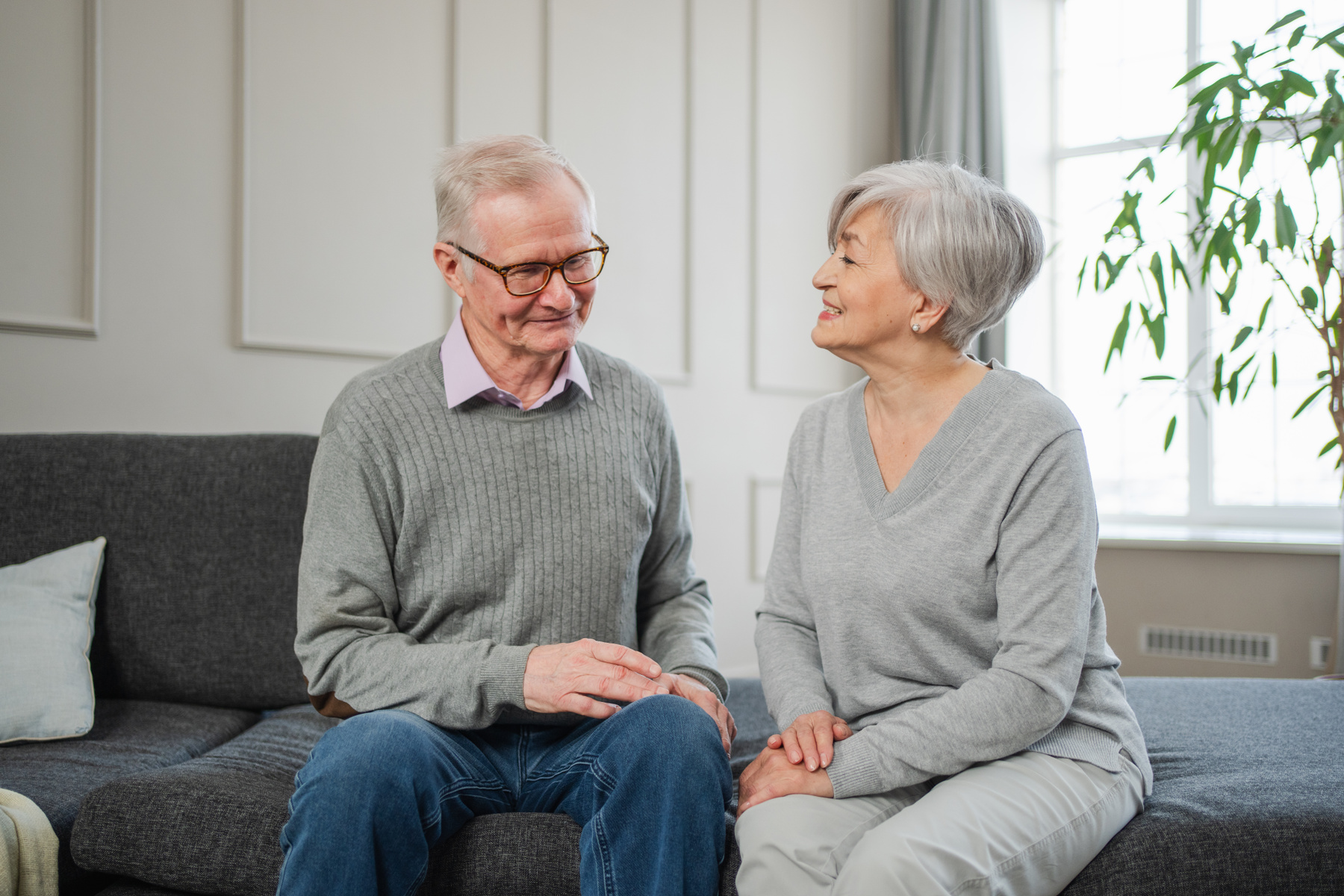 En kvinna och en man sitter i soffan och pratar.