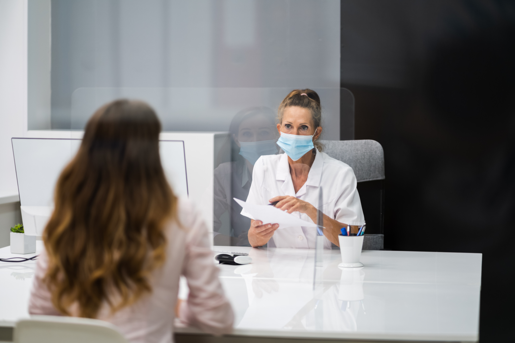 Lääkäri juttelee potilaan kanssa raskaudesta vastaanotolla