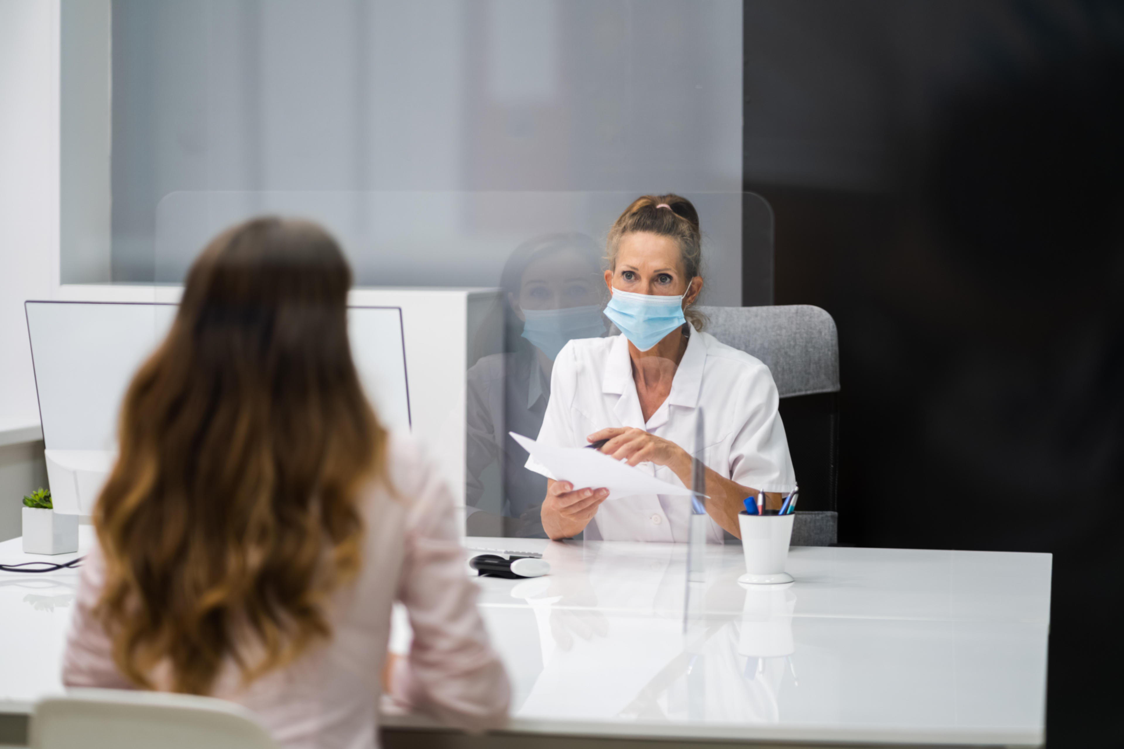 Lääkäri juttelee potilaan kanssa raskaudesta vastaanotolla