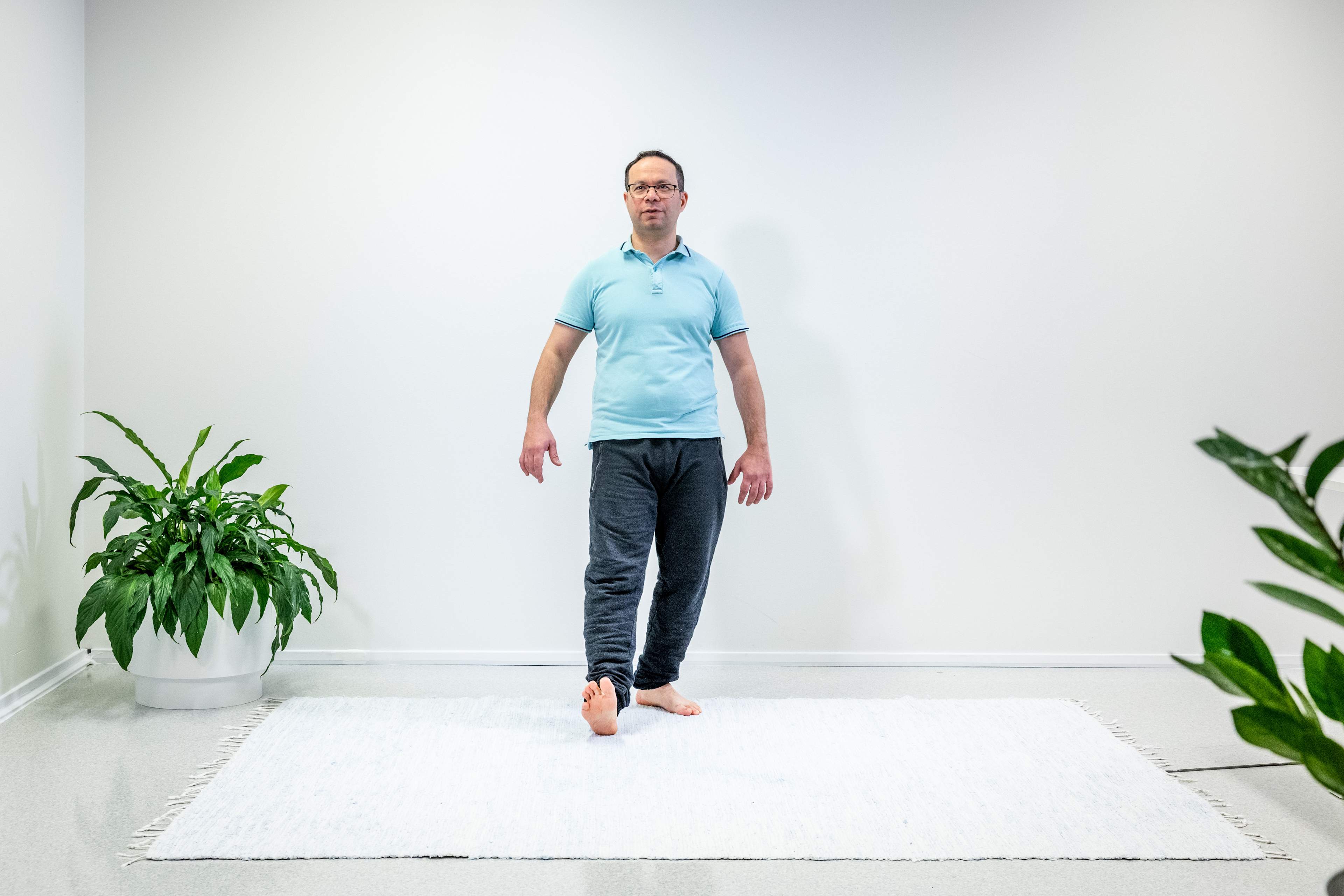 En man har tagit ett steg bakåt med sitt vänstra ben och står på ett ben.