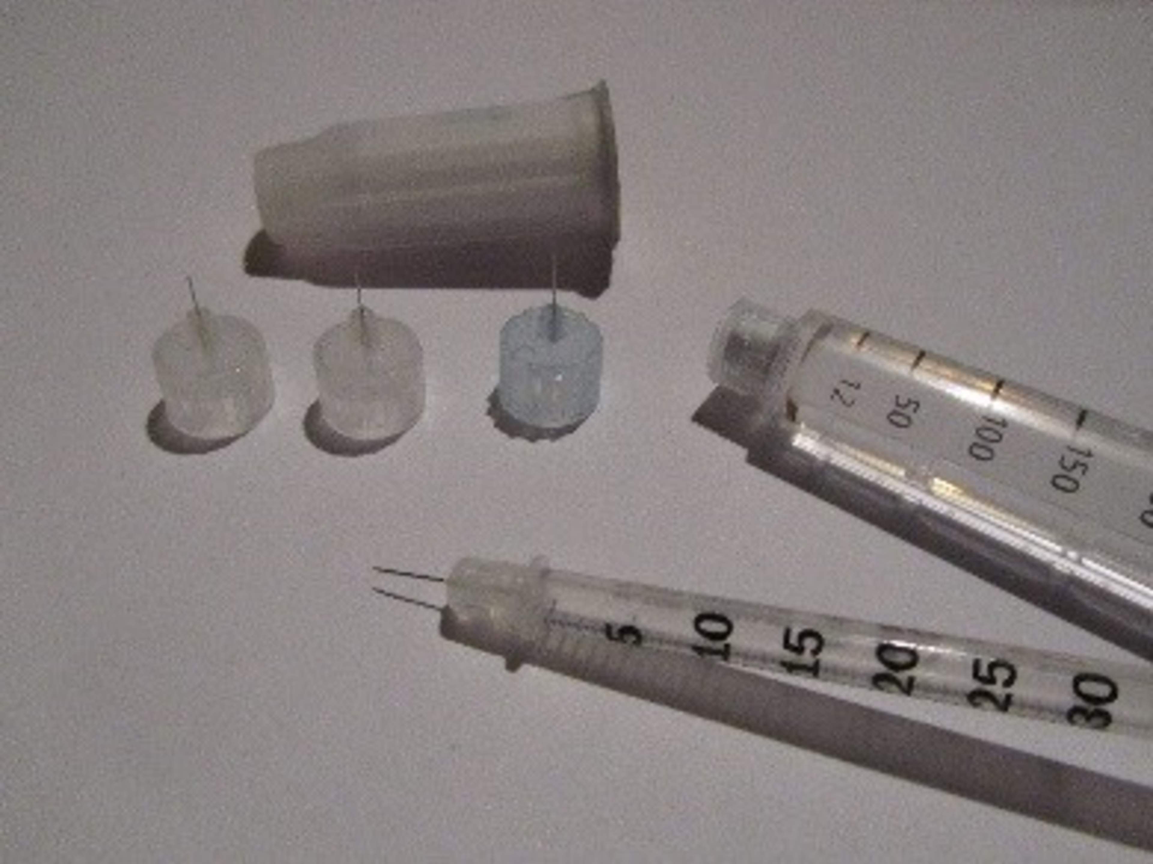 Bilden visar tre olika nålar för insulinpennan, en insulinspruta, en insulinpenna och ett säkerhetsverktyg för att avlägsna nålen.
