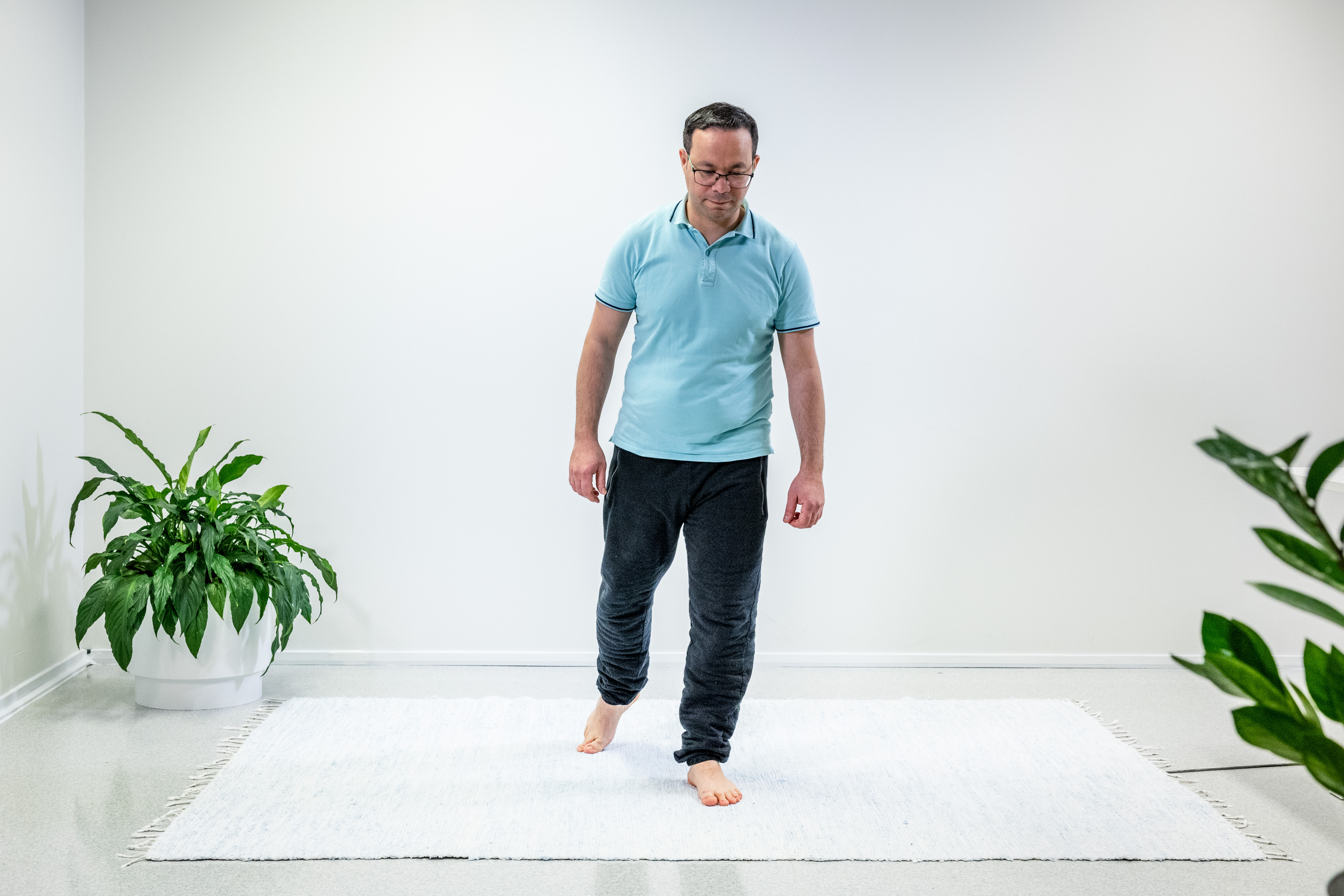 Mies on ottanut askeleen eteenpäin vasemmalla jalalla ja seisoo yhdellä jalalla. 