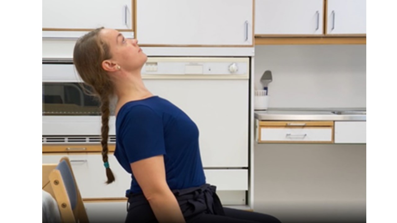 En kvinna sitter och sträcker ut ryggen bakåt.