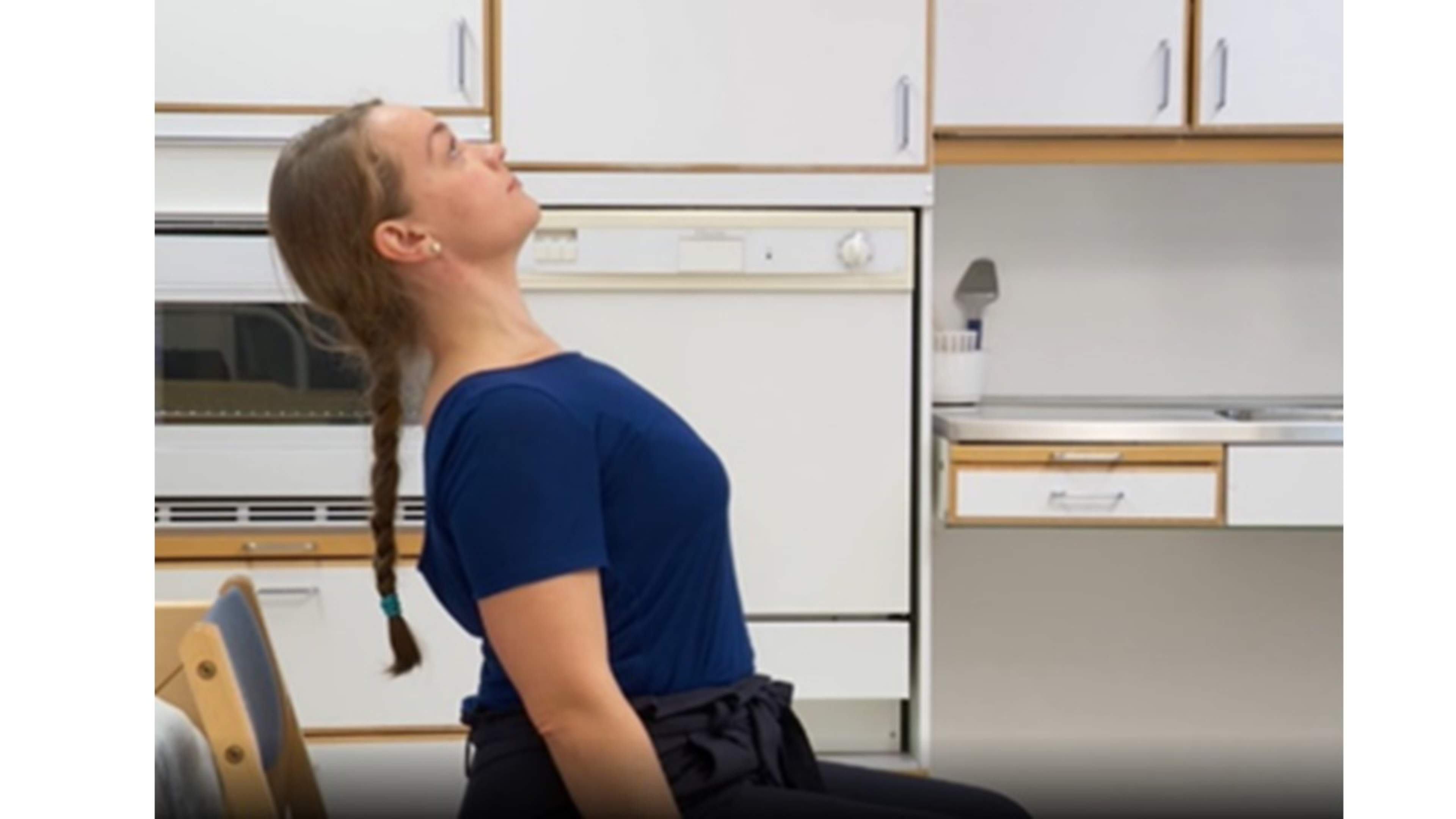 En kvinna sitter och sträcker ut ryggen bakåt.