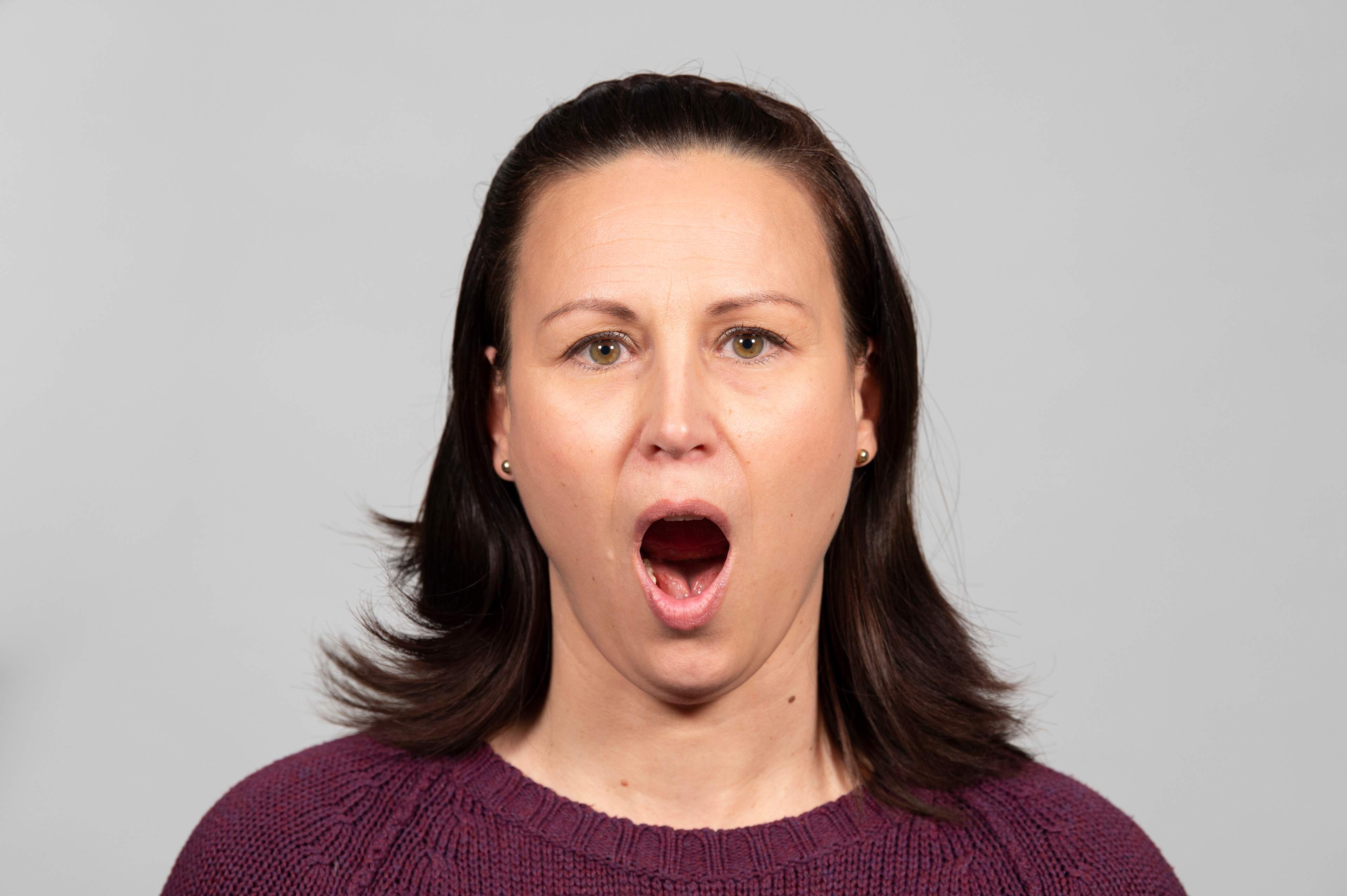 Kvinna har munnen stort öppnad.
