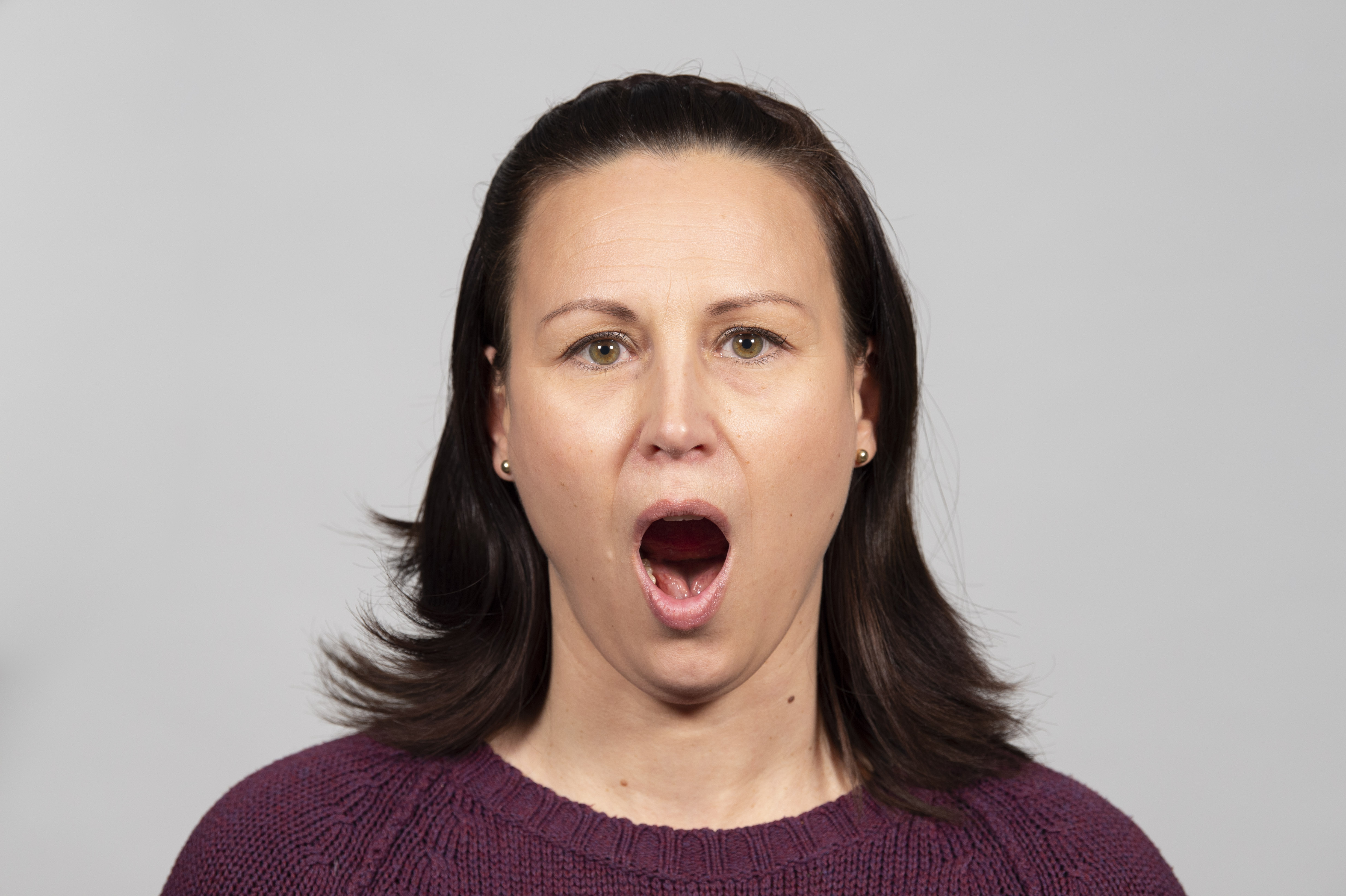 Nainen on suu avattuna suuresti auki. 