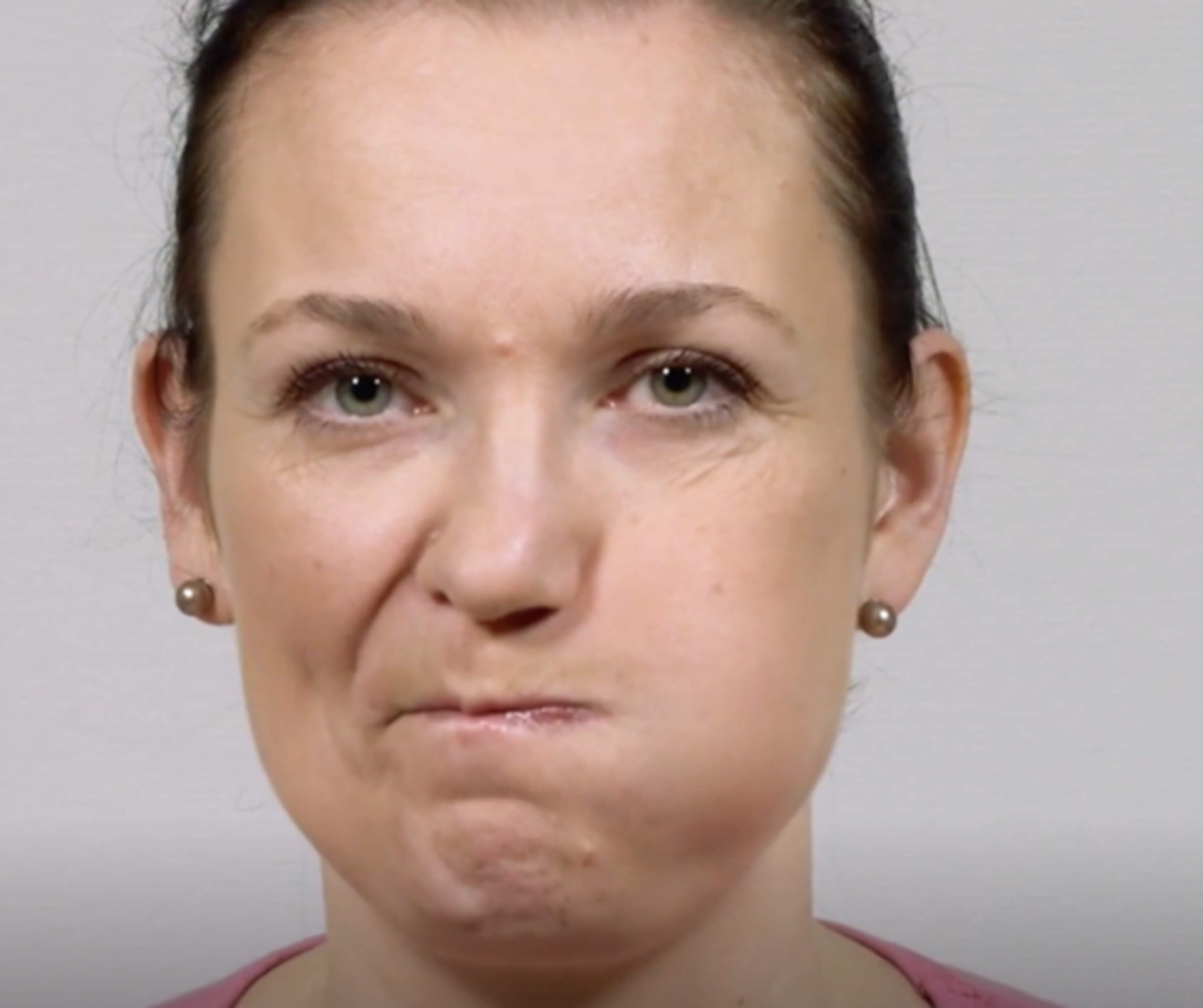 Nainen on puhaltanut ilmaa poskeen.