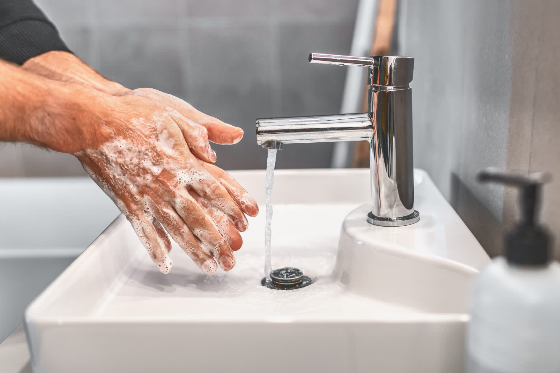På bilden händerna som rengörs och värms under rinnande vatten.