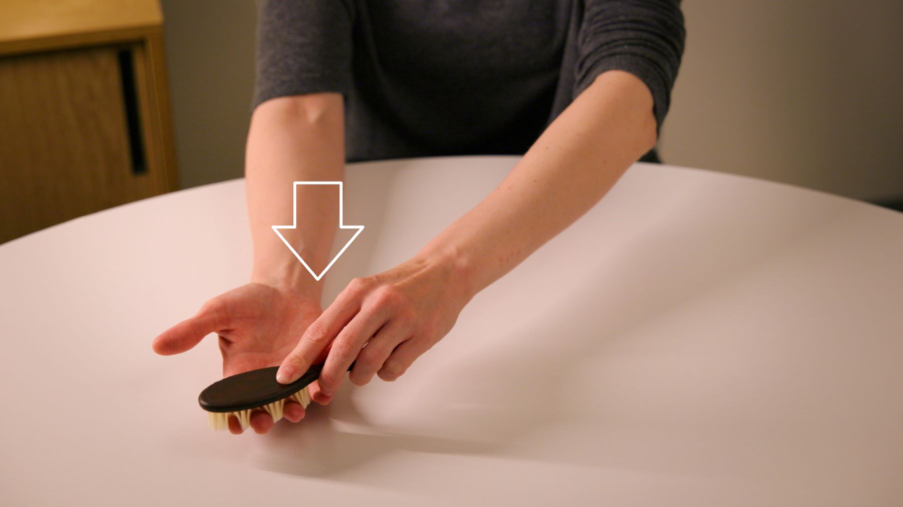 En person borstar sin hand från armvecket mot fingertopparna, med handflatan uppåt.