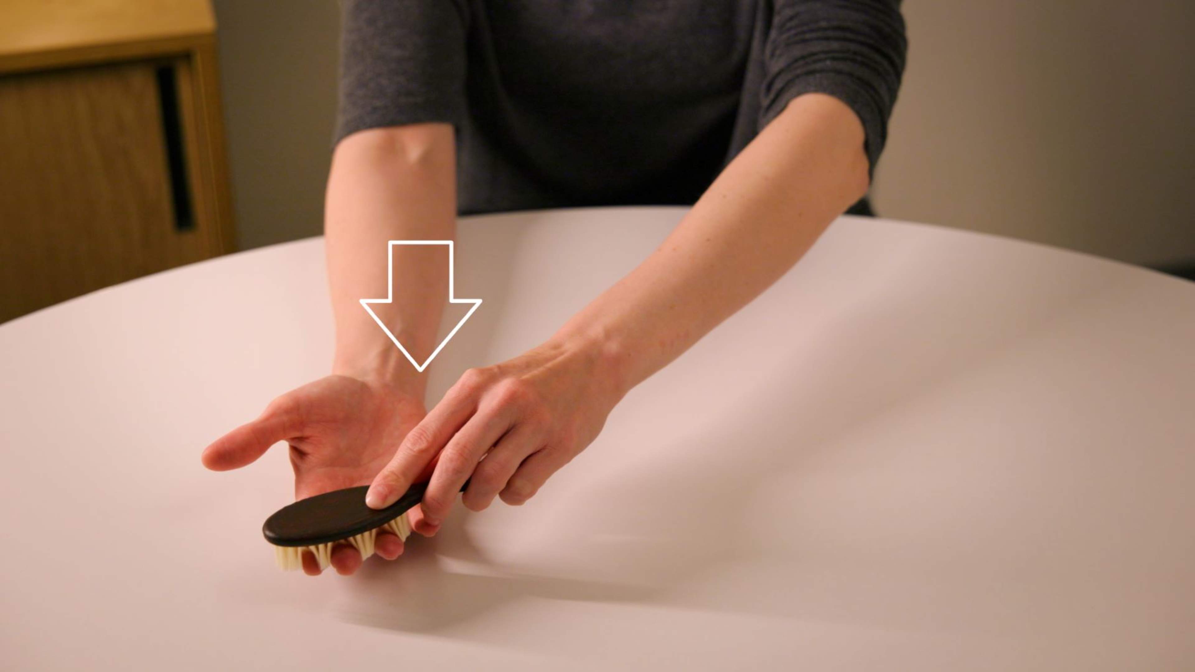En person borstar sin hand från armvecket mot fingertopparna, med handflatan uppåt.