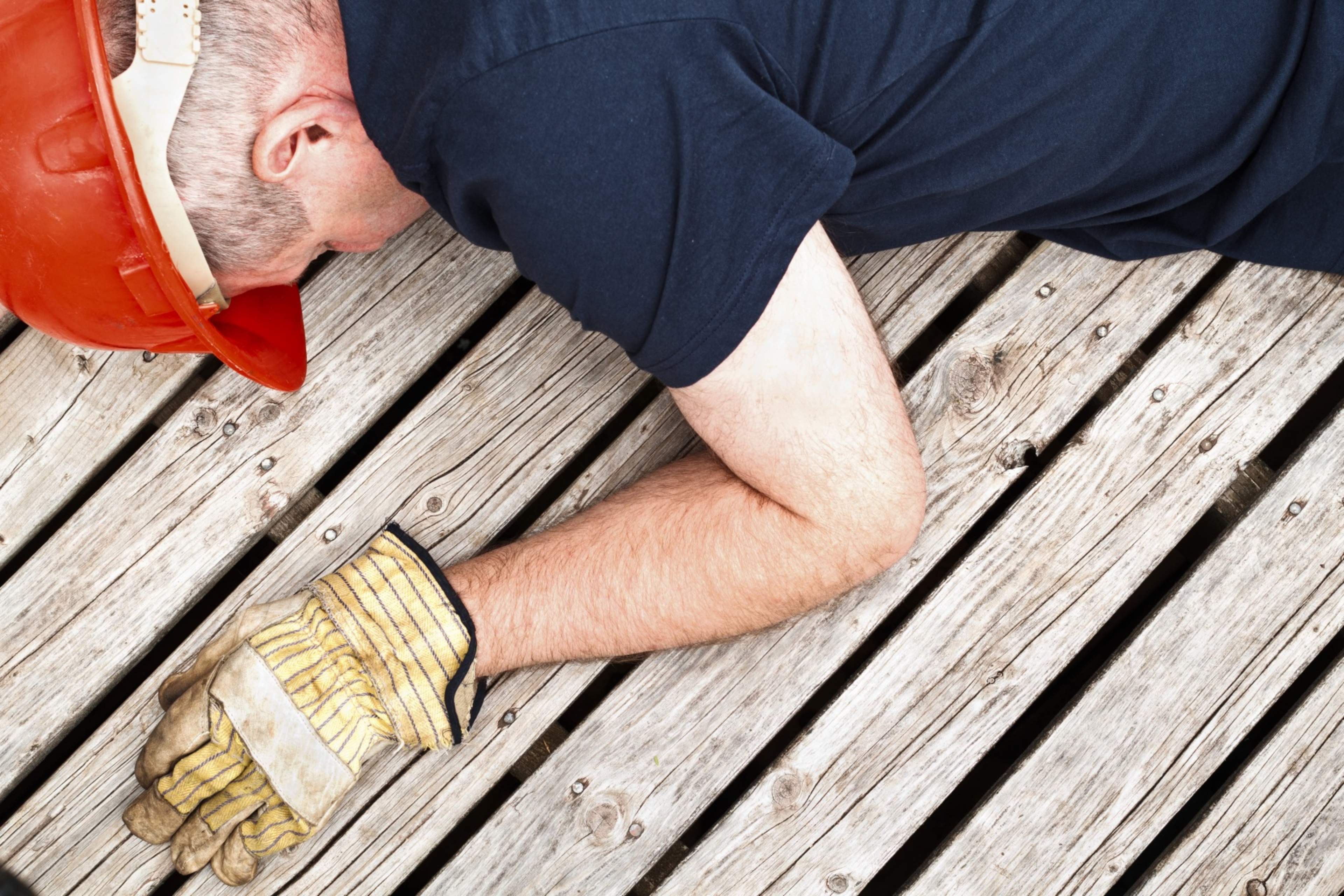 A constructionworker collapsed on a wooden terrace.