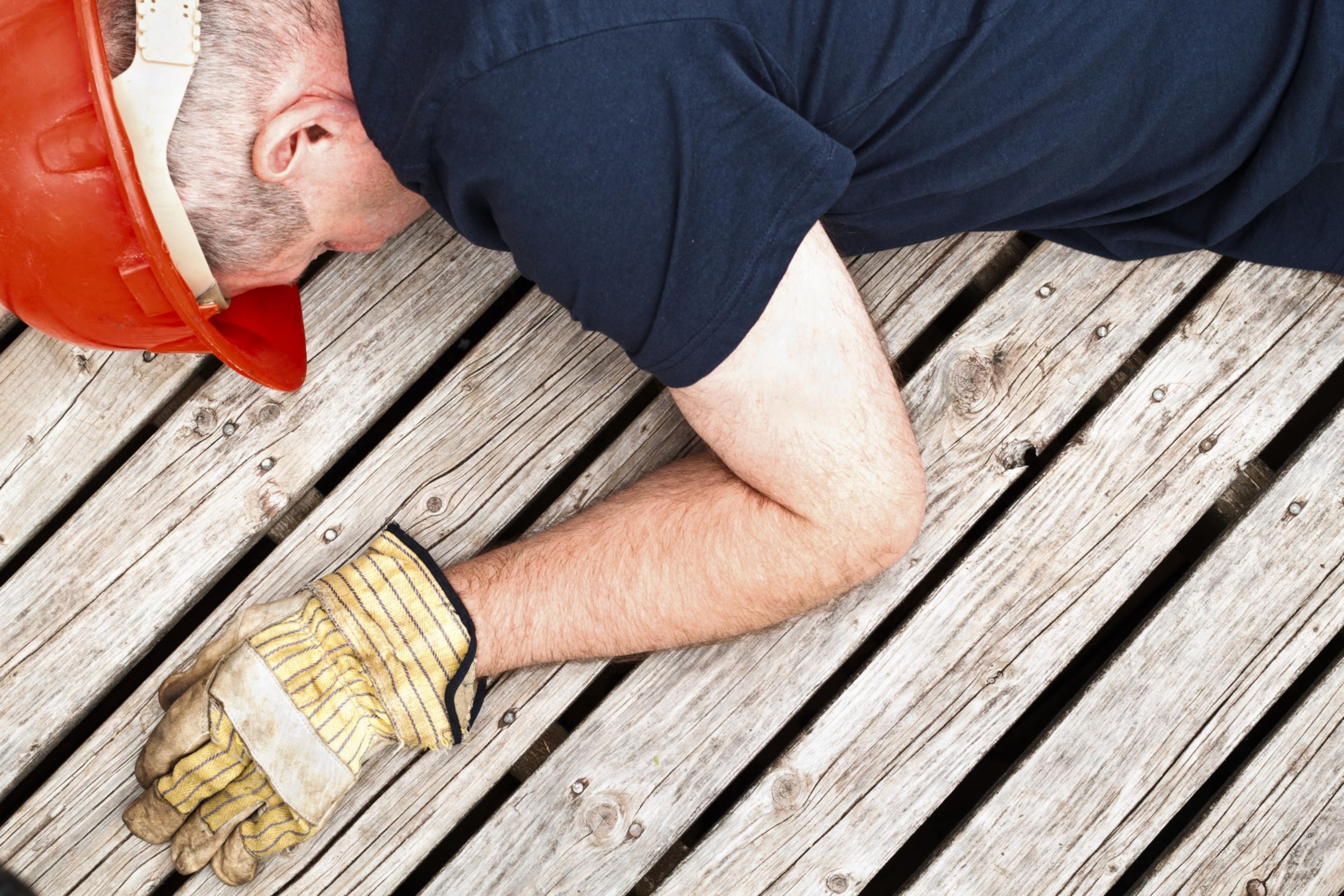 A constructionworker collapsed on a wooden terrace.