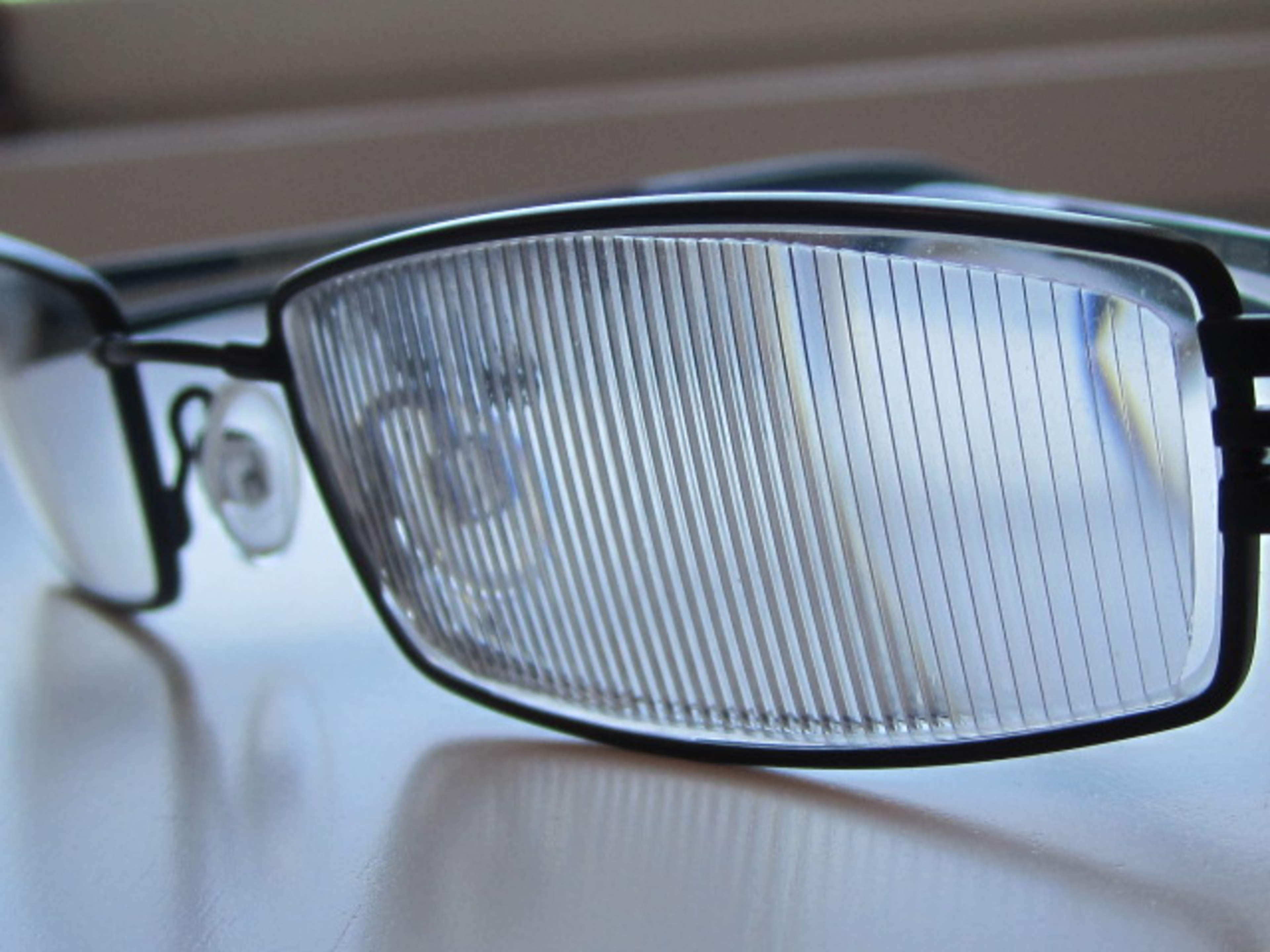 Silmälasit, joissa väliaikainen silmälaseihin kiinnitettävä prismakalvo