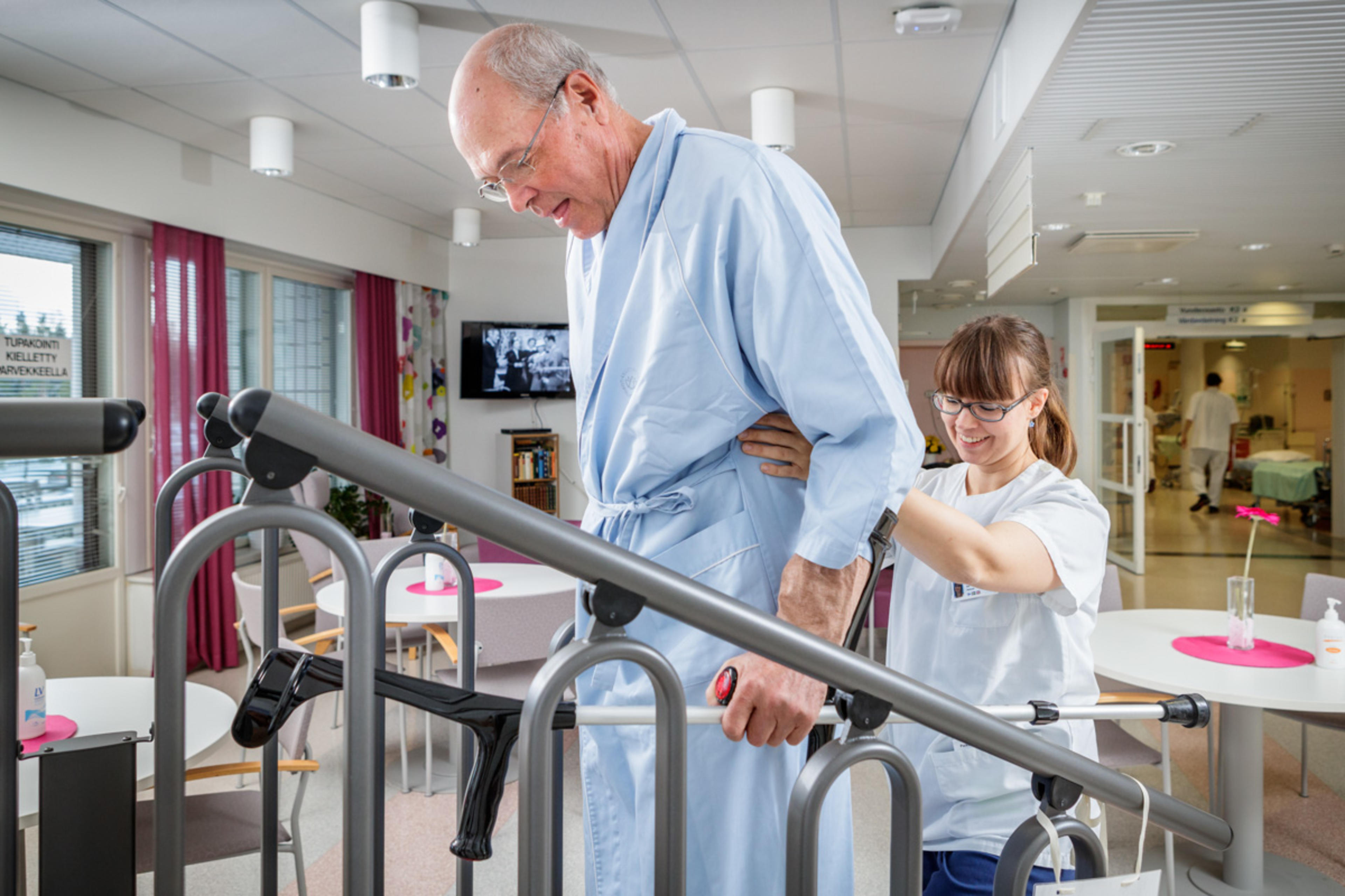 Ledprotespatienterna tränar att gå i trappor på avdelningen med fysioterapeutens stöd.