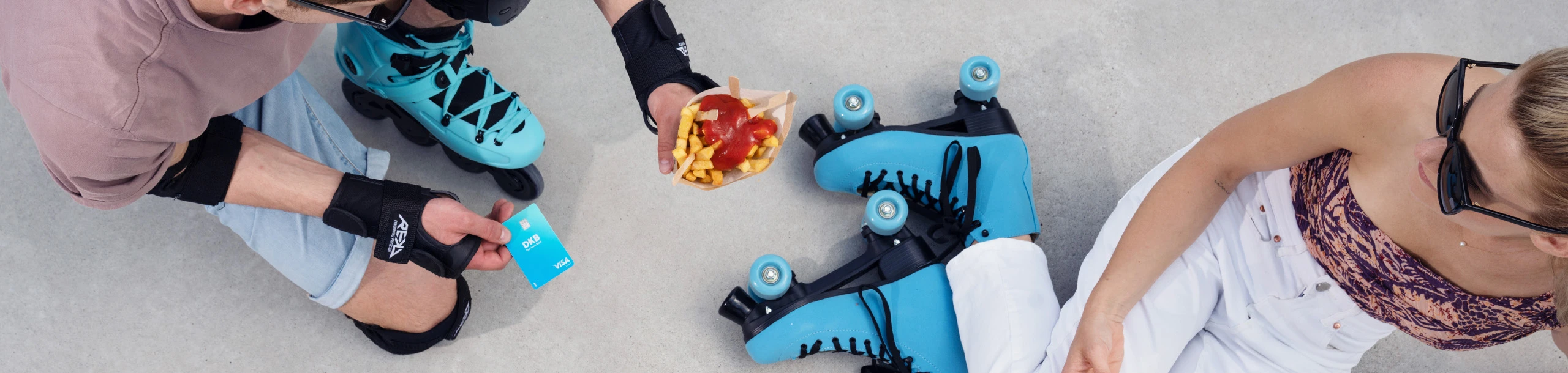 Zwei Studierende mit Rollschuhen und Visa Debitkarte
