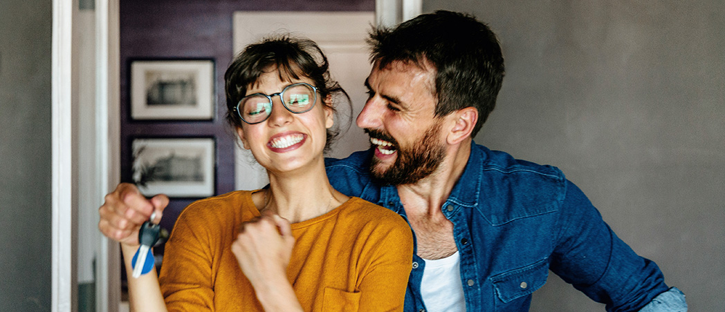 Frau und Mann freuen sich über eine neue Wohnung