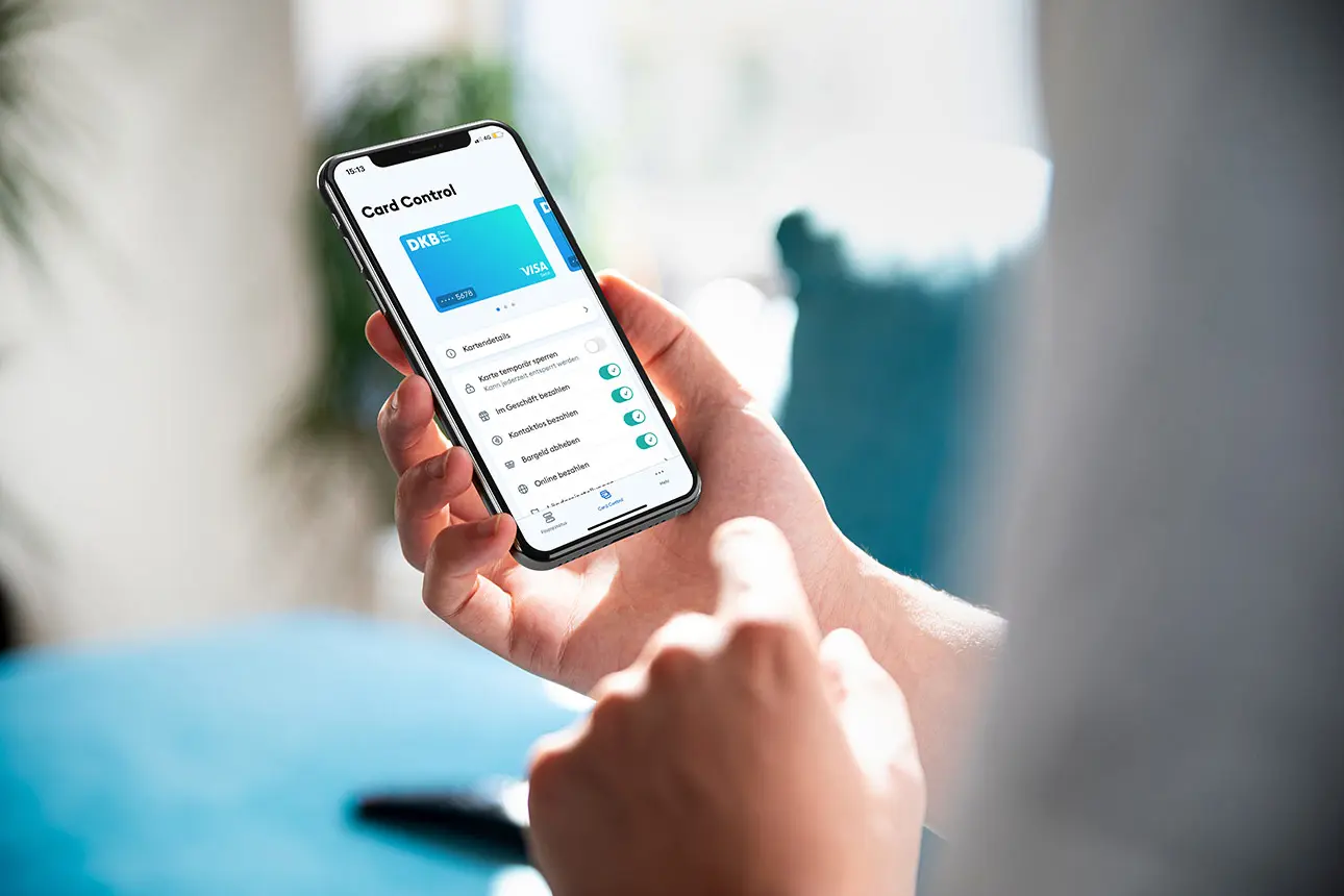 Person hält Smartphone in der Hand mit den Card Control Einstellungen