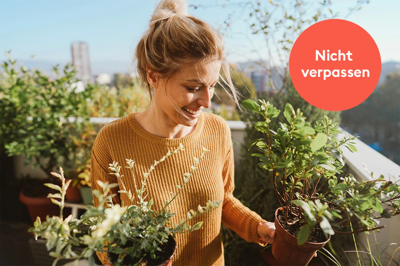 Eine Frau mit Pflanzen auf dem Balkon