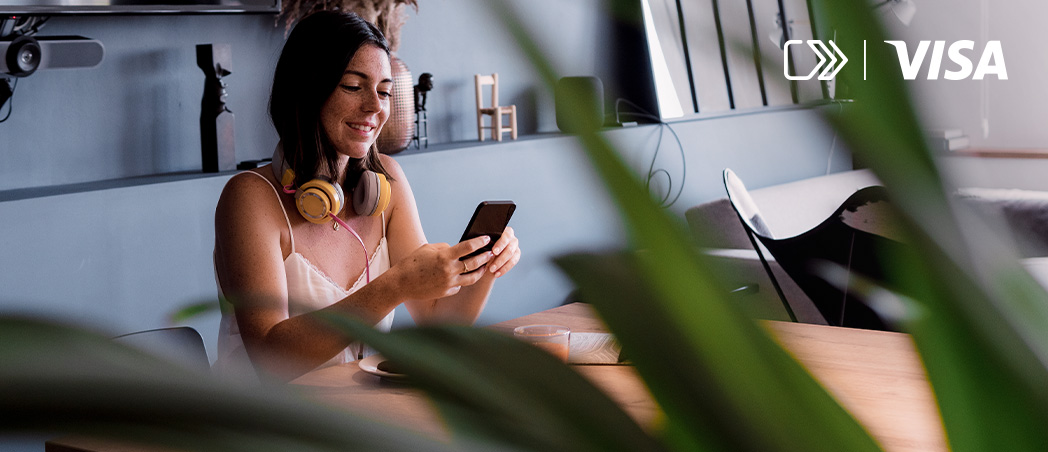 Eine lächelnde Frau schaut auf ihr Smartphone