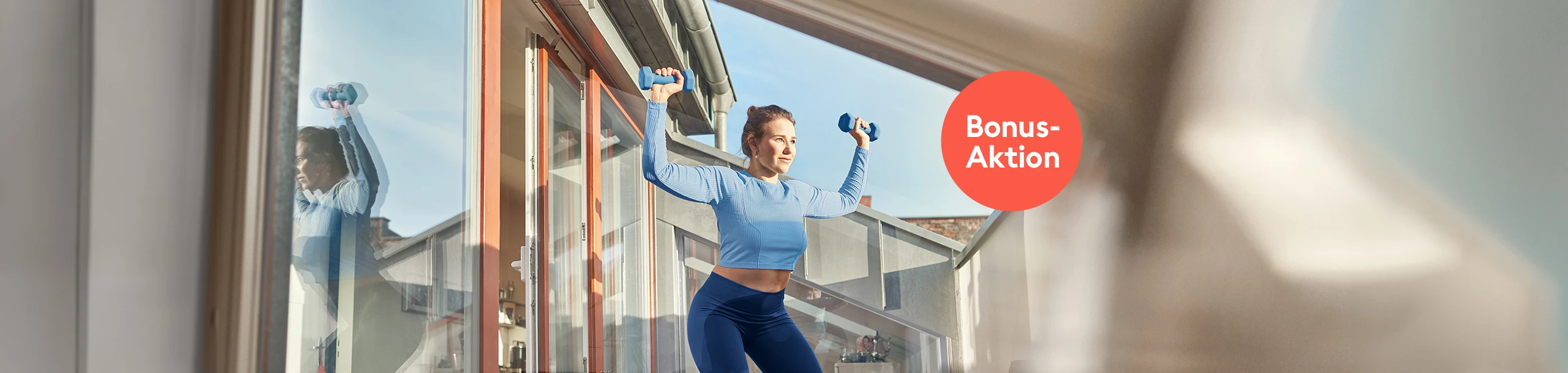 Frau mit Hanteln auf Terrasse