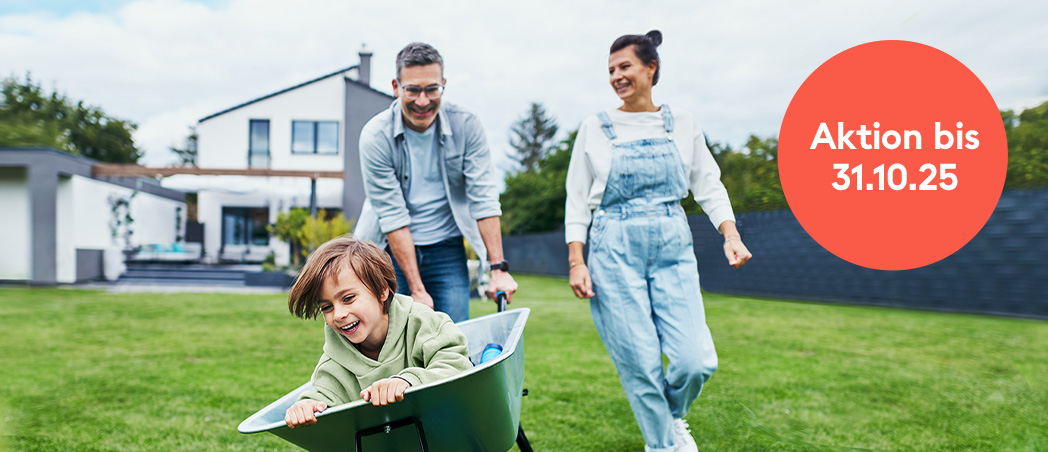 Familie spielt fröhlich im Garten des eigenen Hauses