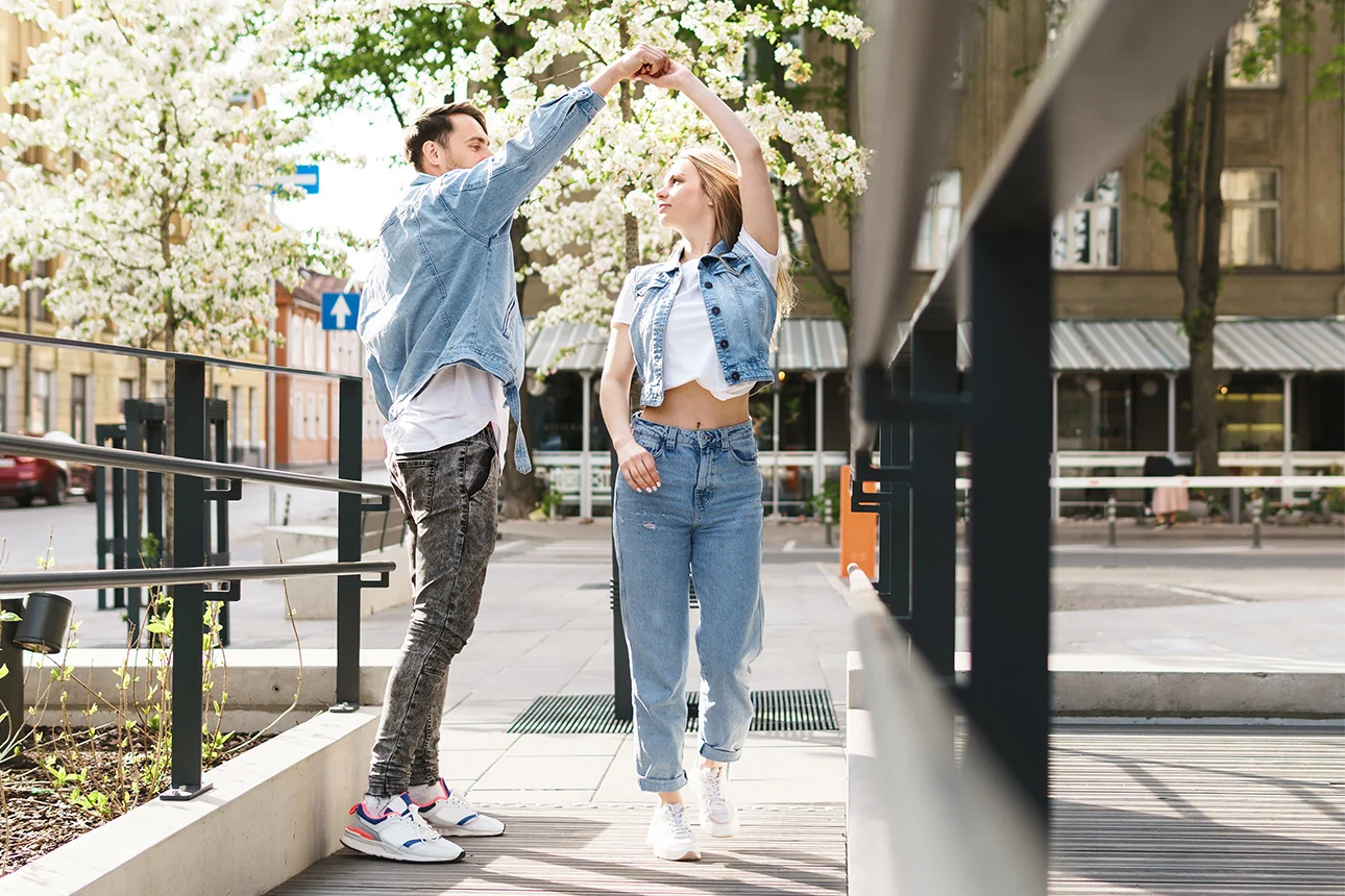 Eine Frau und ein Mann tanzen fröhlich durch einen Tag im Frühling