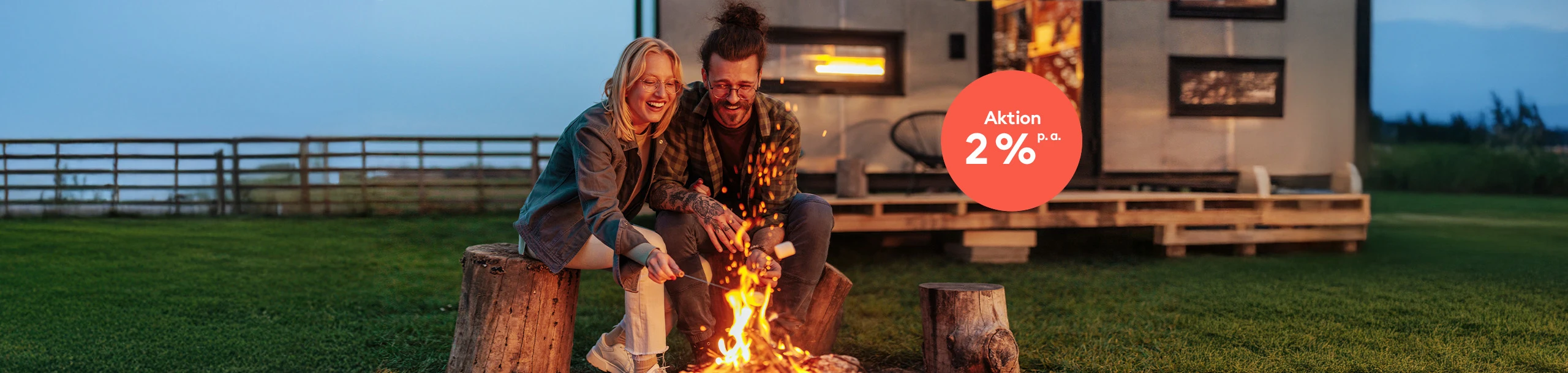 Ein junges Paar sitzt am Lagerfeuer