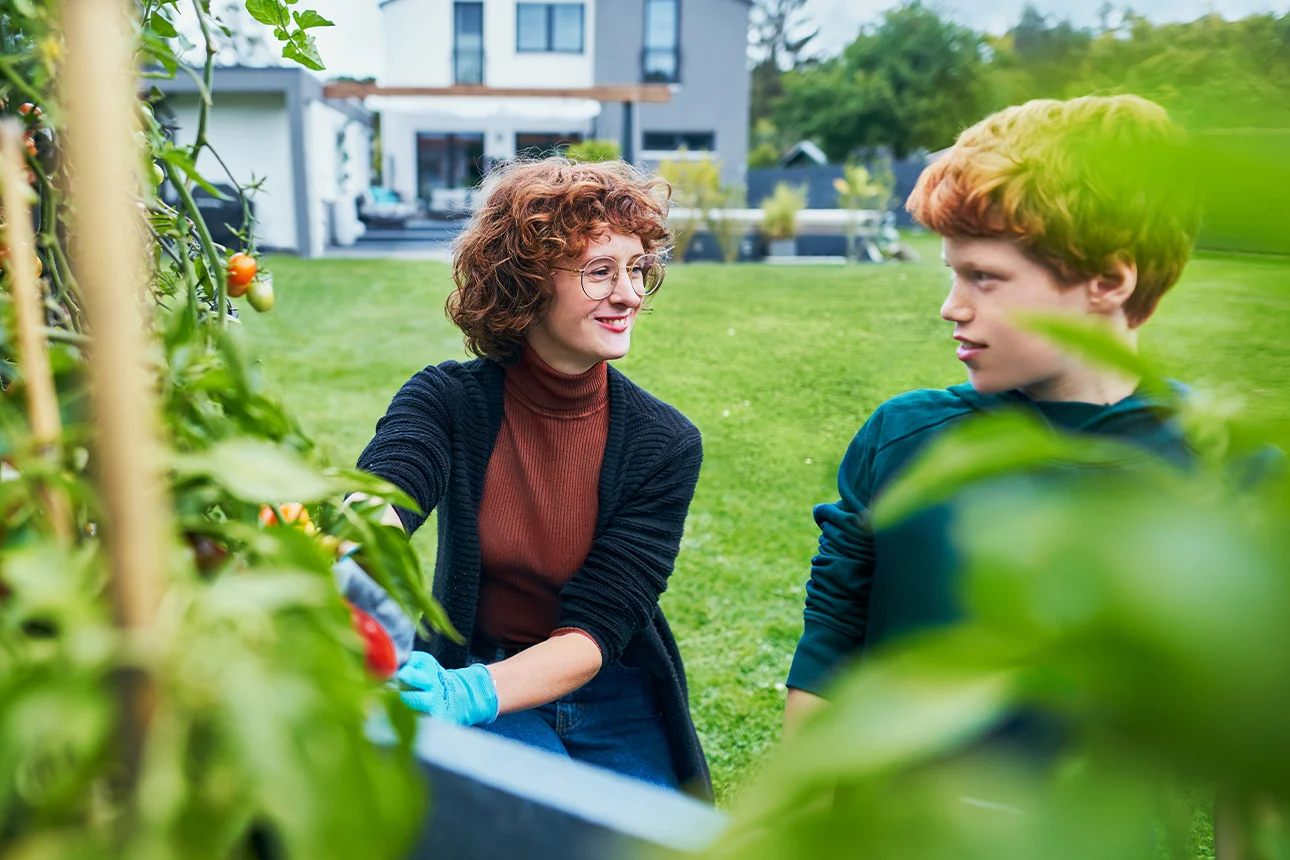 Frau mit Kind sind glücklich im Garten Ihres Hauses