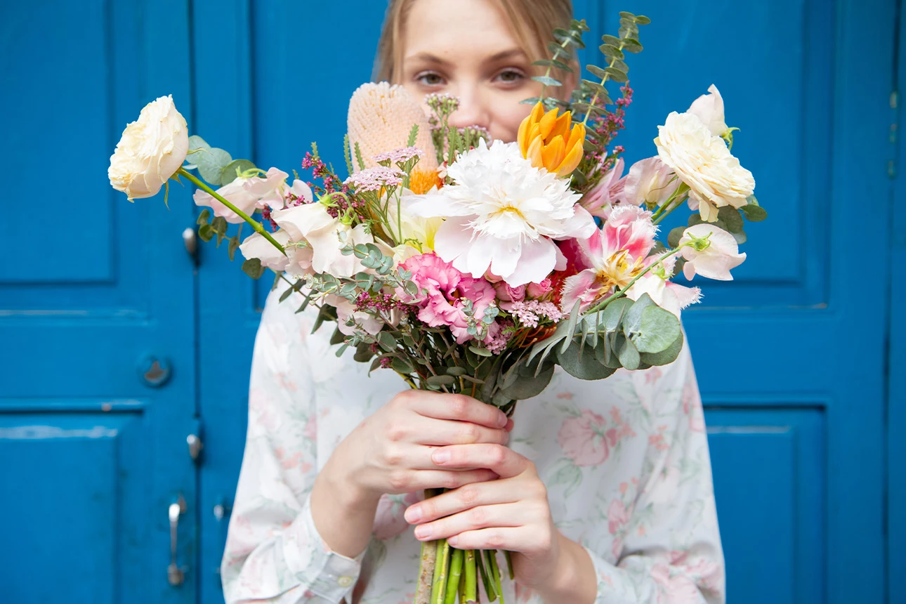 Ein Frau hält einen Blumenstrauß in der Hand