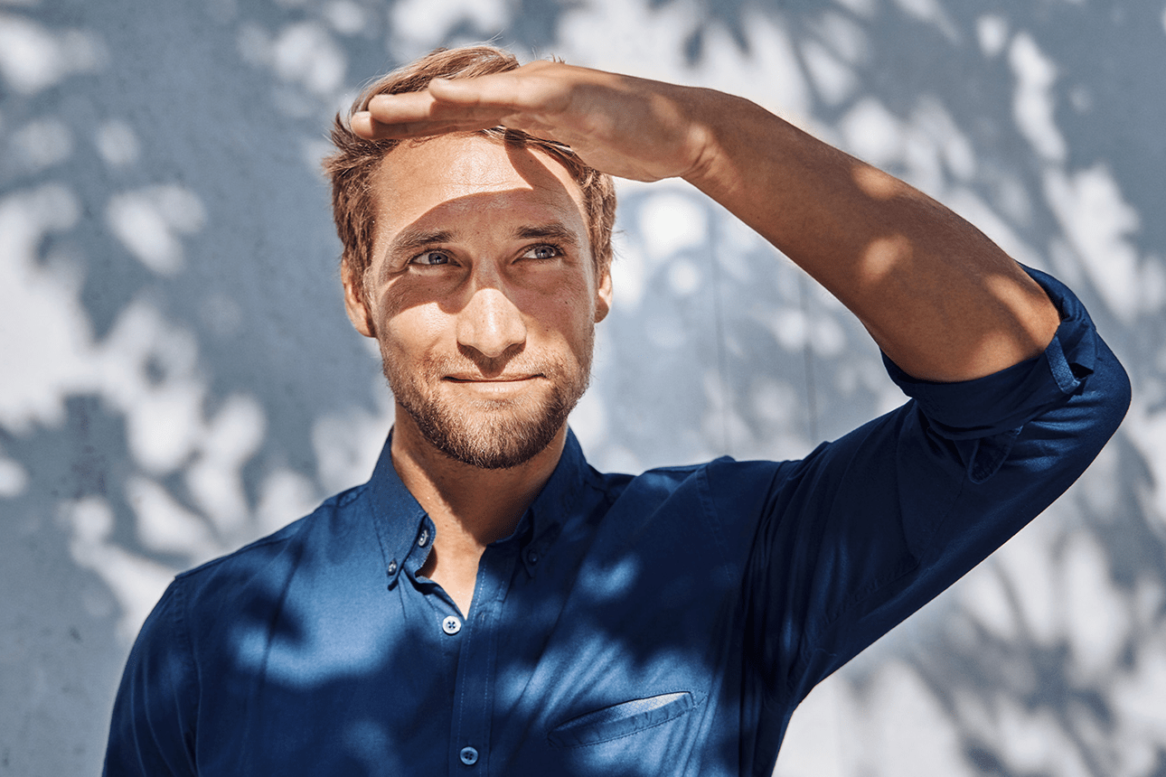 Eine Person steht im Schatten und blickt in die Ferne