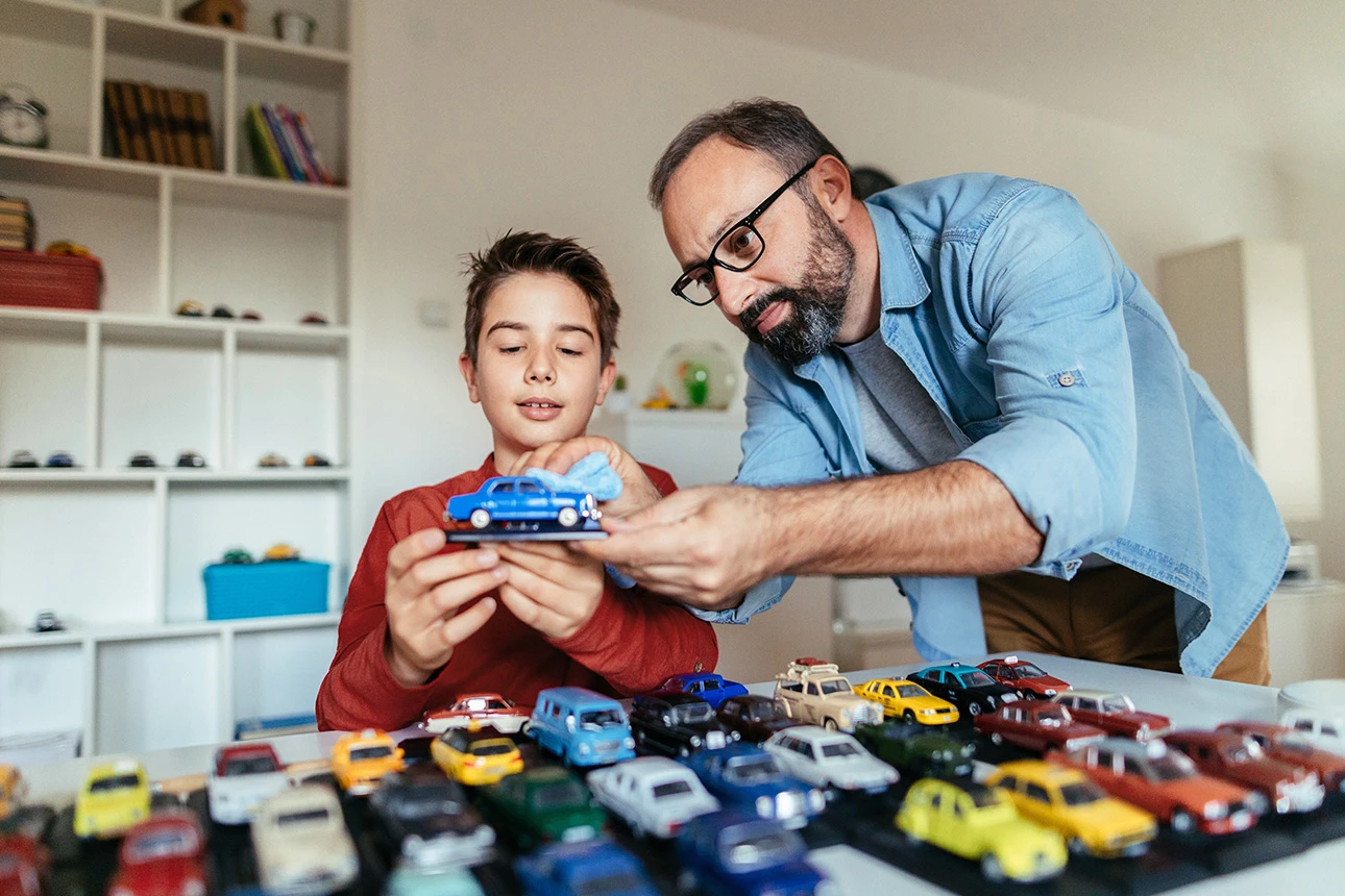 Vater und Sohn schauen sich gemeinsam ihre Autosammlung an