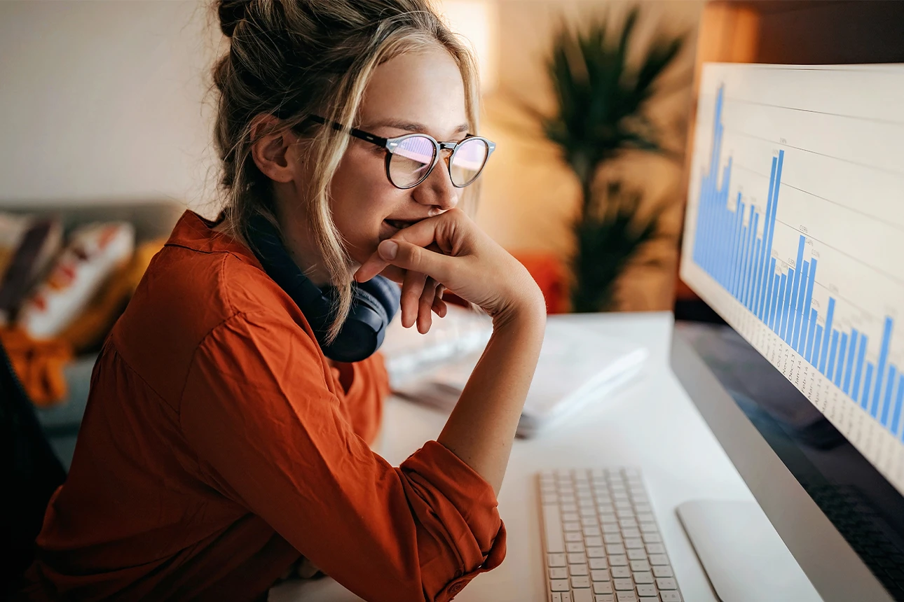 Eine Frau betrachtet einen Computer-Bildschirm mit einem Balkendiagramm.