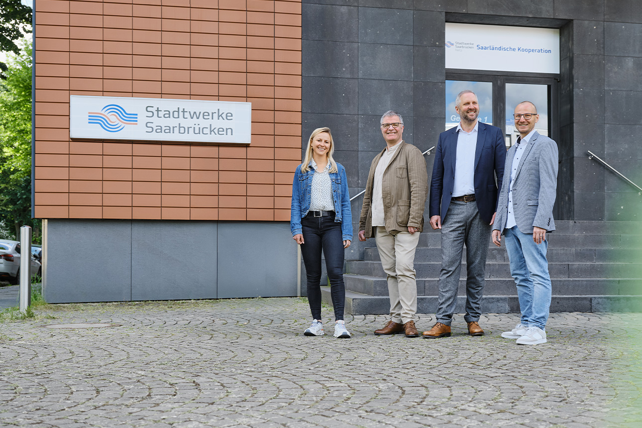 Vier Personen stehen vor dem Eingang des Stadtwerke Saarbrücken Eingangs