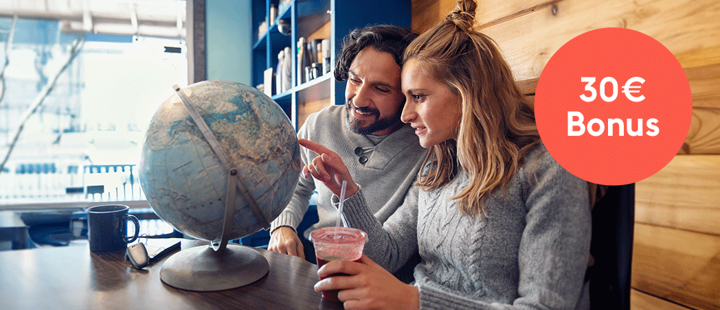 Eine Frau und ein Mann schauen einen Globus an