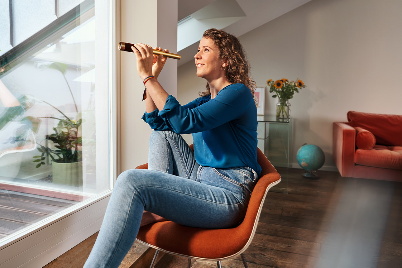 Frau mit Fernglas am Fenster