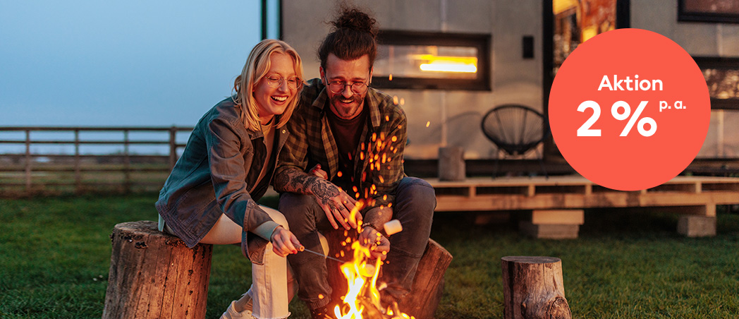 Ein junges Paar sitzt am Lagerfeuer