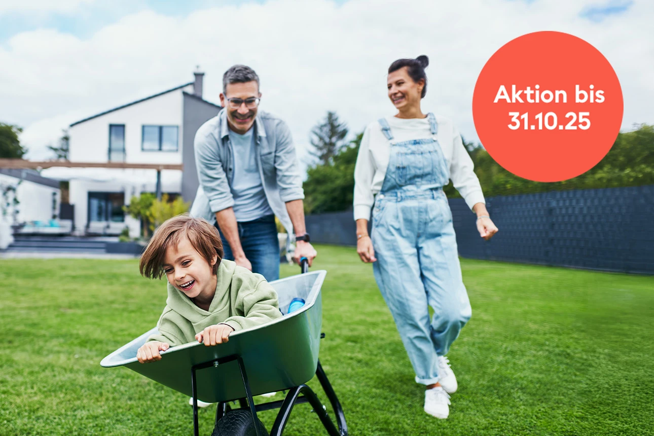 Familie spielt fröhlich im Garten des eigenen Hauses